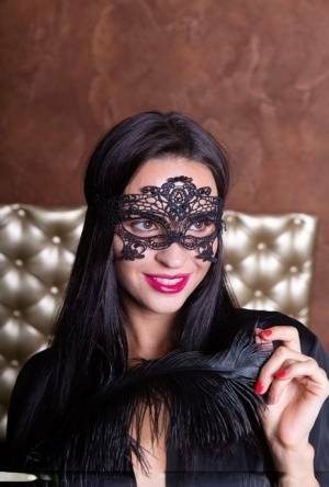 Sexy brunette Leyla Lee removes a mask and robes to pose nude with a feather on girlzfan.com