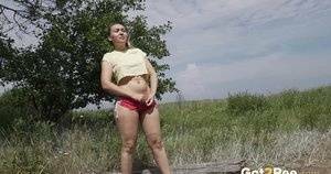 Gorgeous European sits on a log to piss outside on girlzfan.com